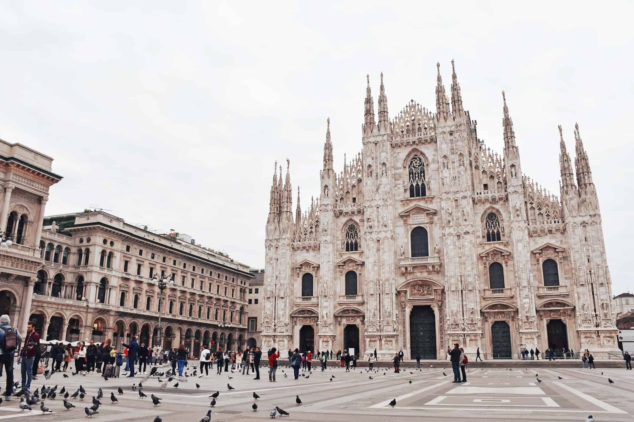 Milan cathedral (duomo di milano) with tourists and pigeons in the piazza del duomo.