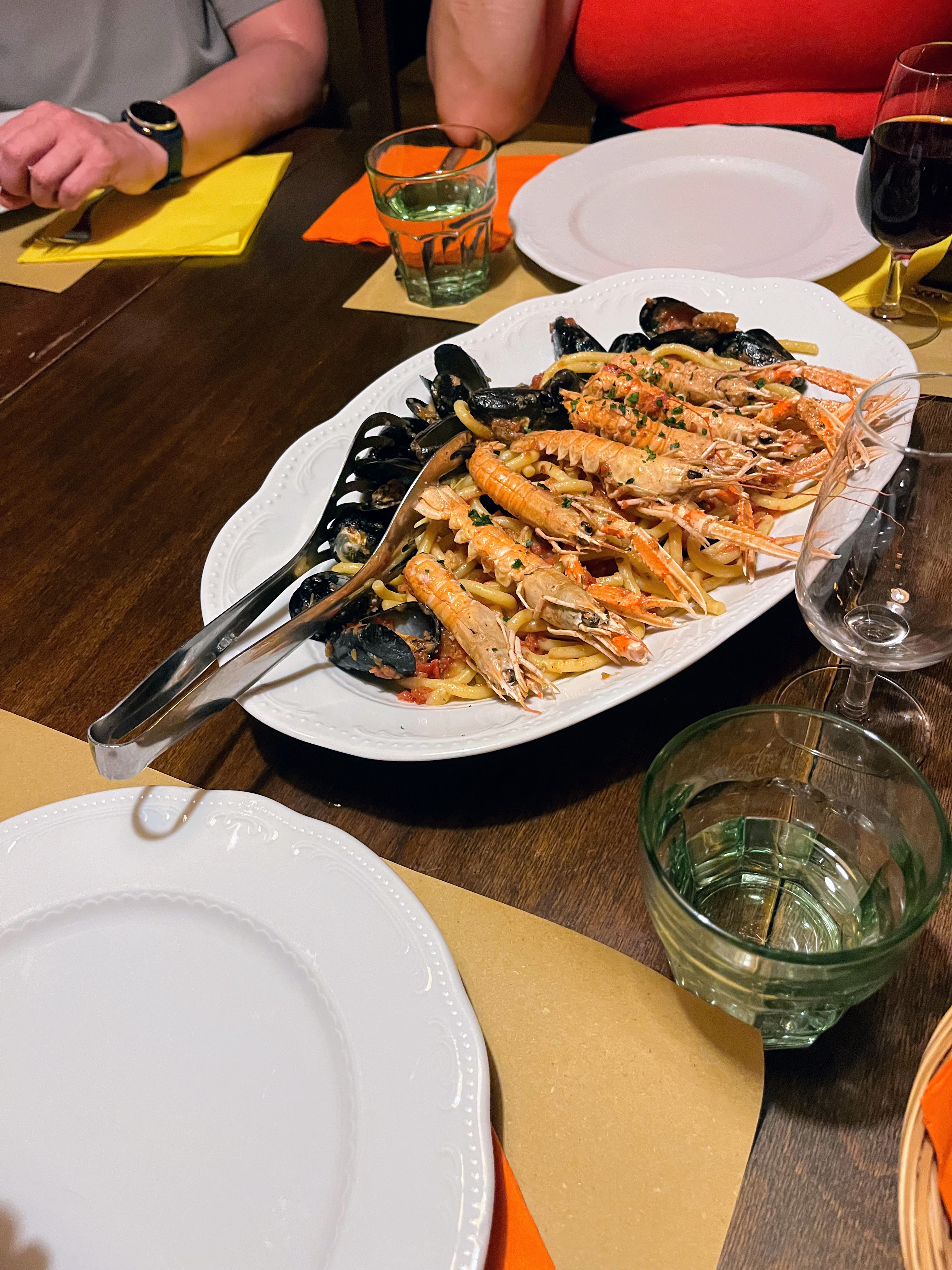 A plate of pasta topped with a variety of seafood