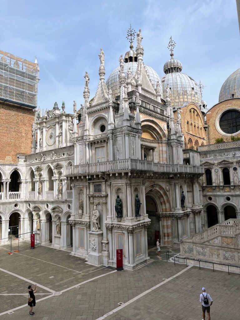 An ornate historic structure in the center of a stone courtyard