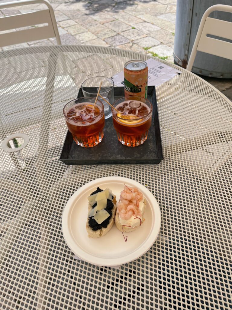 Drinks and a small plate of food on an outdoor table