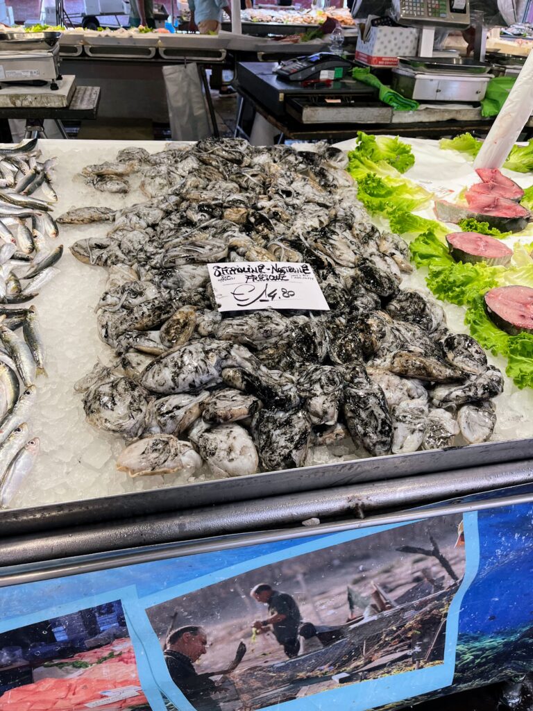 A seafood stand with black and white marbled seafood sitting on a bed of ice