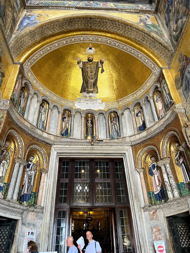 Photo of a domed ceiling covered in gold with a man in ornate clothing